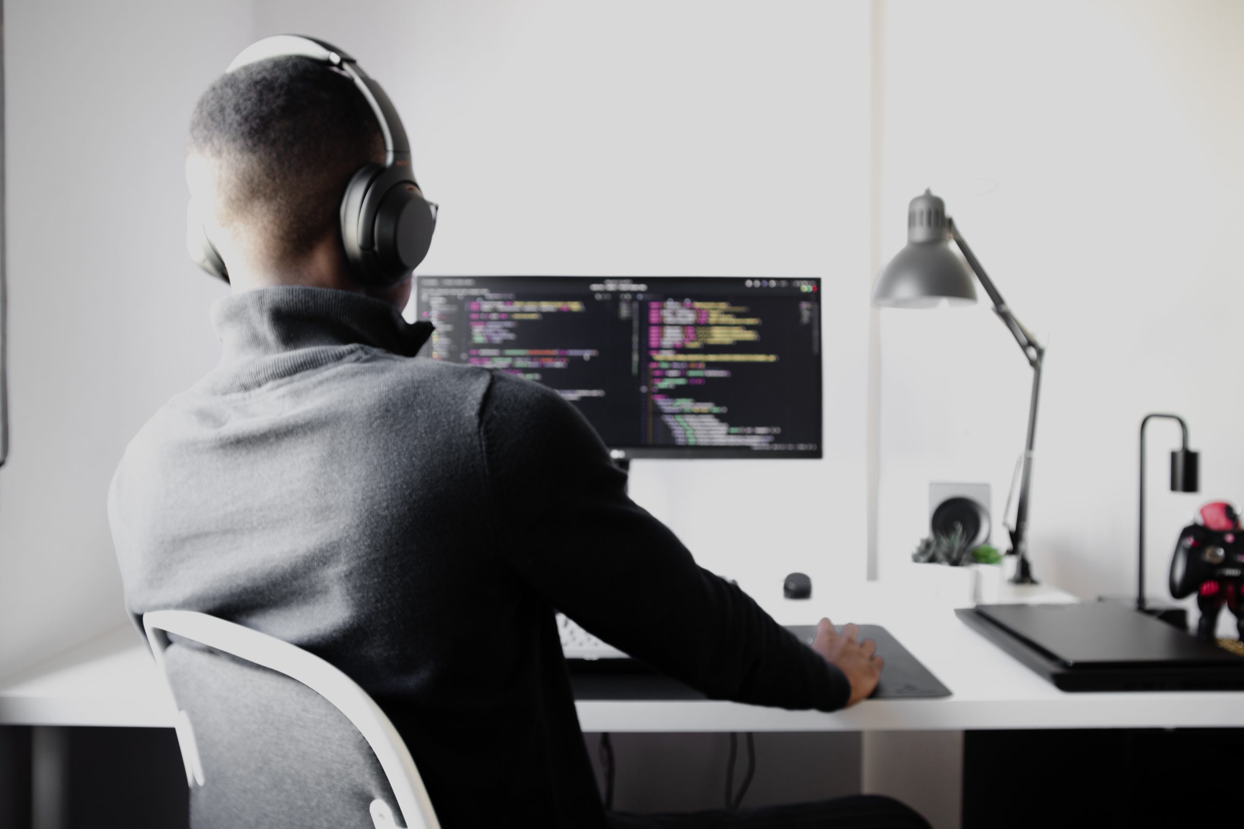 man working on computer with headphones on