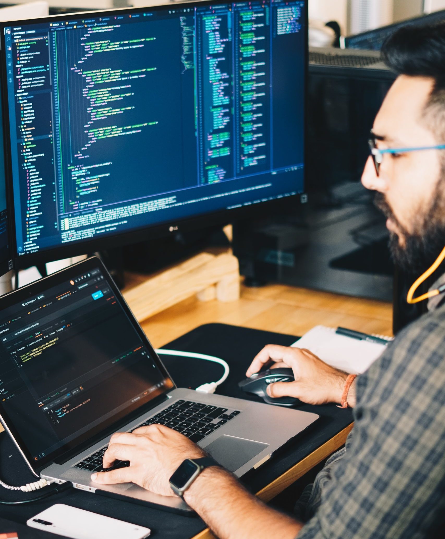 man using macbook while having a monitor on